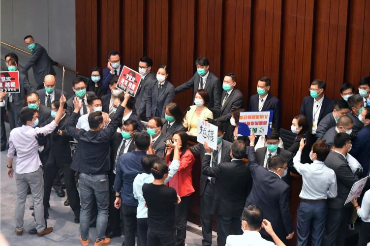 主持內會會議中，李慧瓊被 反對派議員包圍，保安人員被 迫組成人牆阻擋。 記者 馮瀚文攝